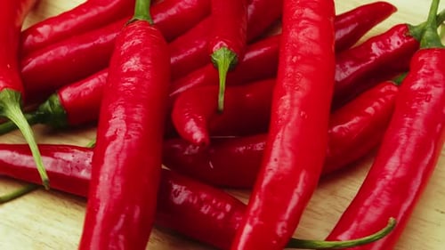 Auf Holzplanken sind reife rote, lange scharfe Chilischoten die weltweit Nummer eins unter den kulinarischen Genüssen und Barmitteln