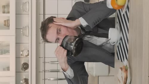 Worried Man With Coffee Pot in Kitchen