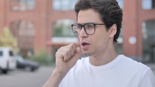 Outdoor Portrait of Sick Young Man Coughing