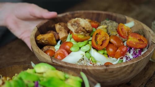 Close Up of Human Hands Serving Two Big Appetizing Vegetable Bowls with Fresh Healthy Vegan Products