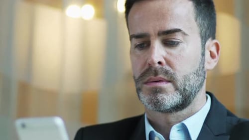 Smiling Man Looking at Phone in Business Suit