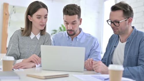 Business Colleagues Working Together on Laptop in Office