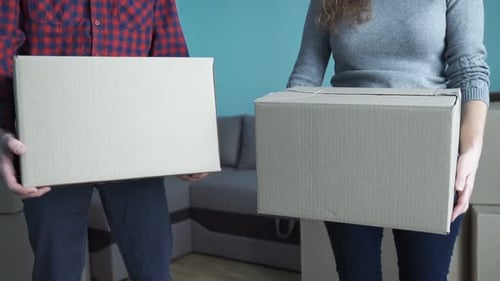 Couple Carry Cardboard Boxes Into New Home