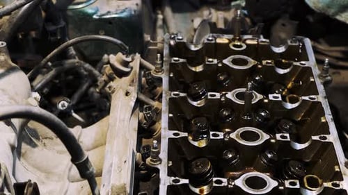 Disassembled car engine in oil. Cylinder head of an automobile engine. Repaired car inside. Sixteen