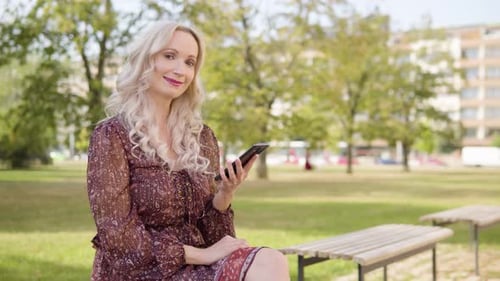 Woman Using Cell Phone in Green City Park