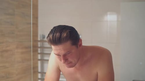 Sad Man Looking in the Bathroom Mirror