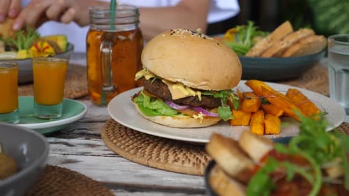 Delicious Vegan Burger with Sweet Potato Fries on Table