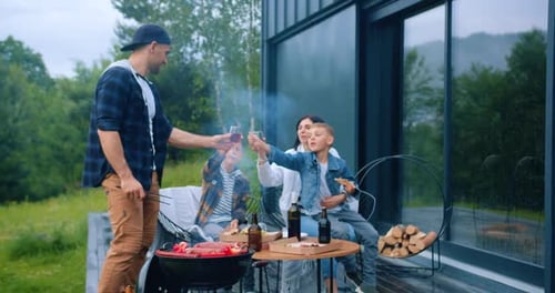 Family Enjoying Food and Drinks at Home Cookout
