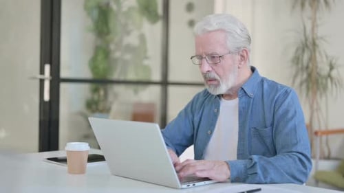 Senior Man Working on Laptop at Home Office