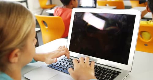 Mädchen benutzt Laptop im Klassenzimmer