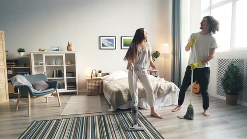 Couple Dancing and Cleaning Bedroom Together