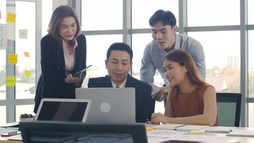Team Collaborating on Laptop in Bright Urban Office