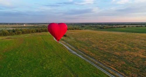 Red Heart Hot Air Balloon over Green Fields