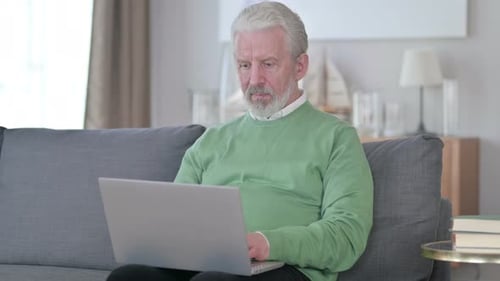 Senior Man Working on Laptop at Home