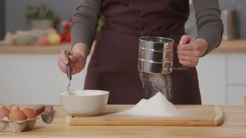 Sifting Flour for Baking in Bright Kitchen