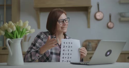 Woman Teaching Math Online with Laptop and Problems