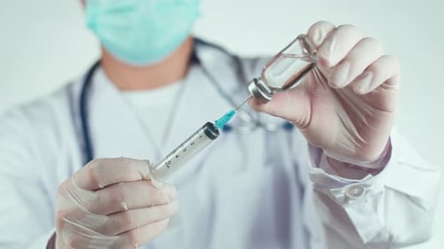 Doctor Filling Syringe with Liquid Medicine from Vial