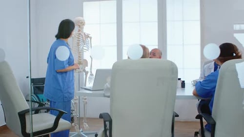 Medical Nurse Pointing on Cervical Spine of Human Skeleton