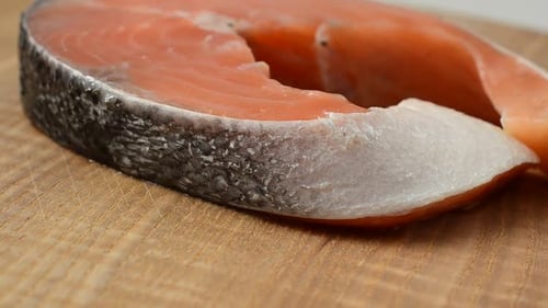 Raw Salmon Steak on Wooden Cutting Board