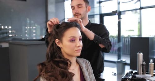 Stylist Creates Hairstyle for Elegant Woman in Salon