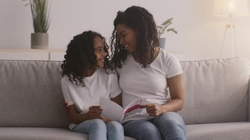 Smiling Girl Gives Mom a Homemade Birthday Card