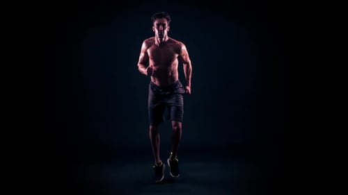 Man Jogging in Place against Black Backdrop