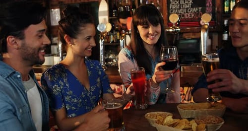 Friends toasting drinks together in bar