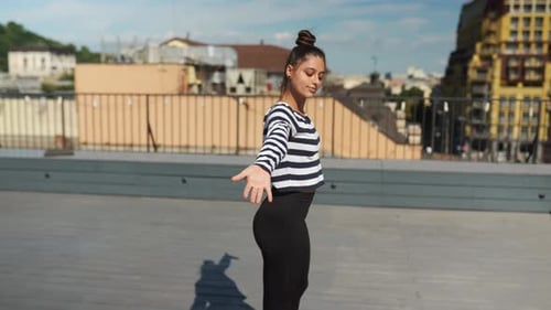Woman Stretching on Rooftop with City View
