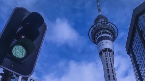 Towering Skyscraper and Traffic Light Under Blue Sky