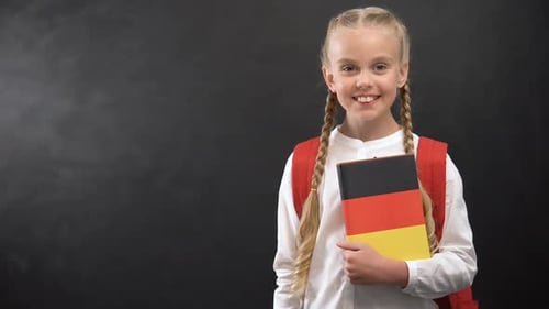 Smiling Girl Holding German Flag Book in School