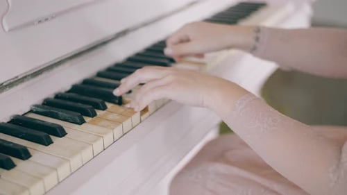 Female Hands Playing Piano. Woman Touches Fingers on Keys. Close Up