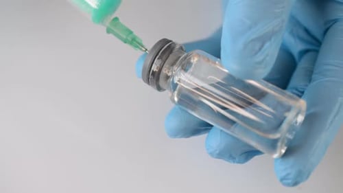 The Doctor Picks Up the Medicine in a Syringe