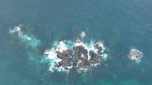Olas chocan contra rocas en el océano