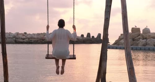 Woman on Beach Swing at Sunset