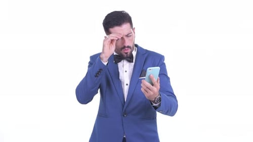Frustrated Man in Suit Using Phone