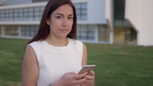 Woman Using Mobile Phone Outdoors in Urban Setting