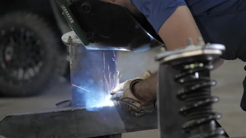 Verfahren zum Schweißen. Schweißer im Helm arbeitet, Arbeiter arbeitet in der Autowerkstatt