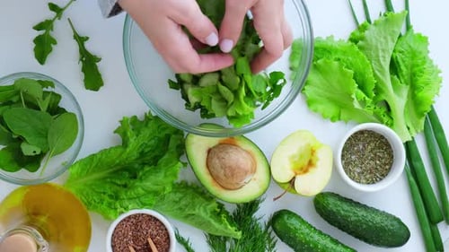 Woman Mix Salad of Fresh Green Vegetables and Herbs