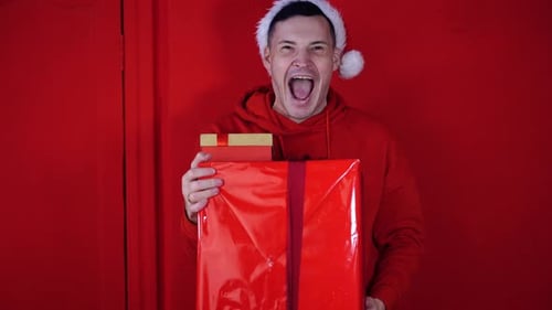 Excited Man Holding Christmas Presents in Red