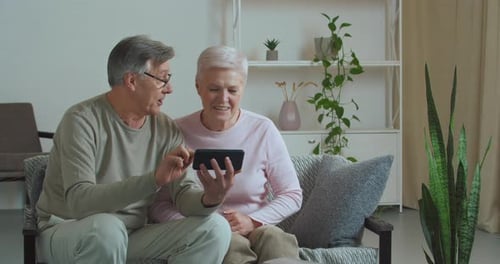 Senior Couple Using Smartphone Together at Home