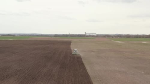 Following Tractor Plowing The Farm Field