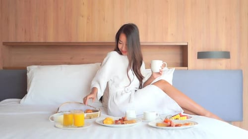 Woman in Robe Having Breakfast in Bed
