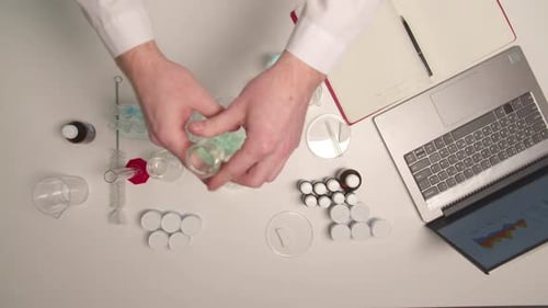 Un technicien de laboratoire mélange des substances dans une fiole