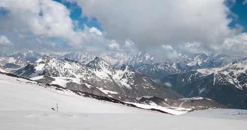 Air Flight Through Mountain Clouds Over Beautiful Snowcapped Peaks of Mountains and Glaciers