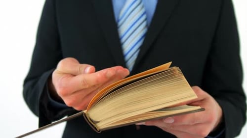 Mittelteil eines Geschäftsmannes blättert Seiten des Buches um