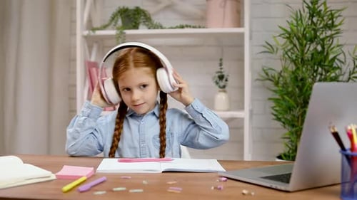 Girl Enjoys Music with Headphones at Desk