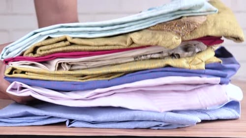 Putting Stack of Cloths on Table