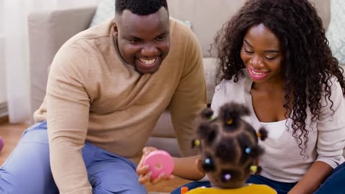 Afrikanische Familie spielt zu Hause mit kleiner Tochter