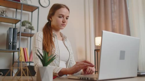 Young Woman Girl Using Laptop Computer Sitting at Table Working Typing on Keyboard From Home Office