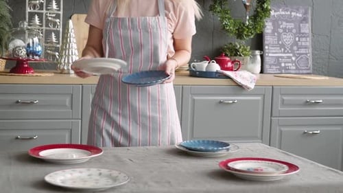 Woman Sets Table with Plates in Kitchen
